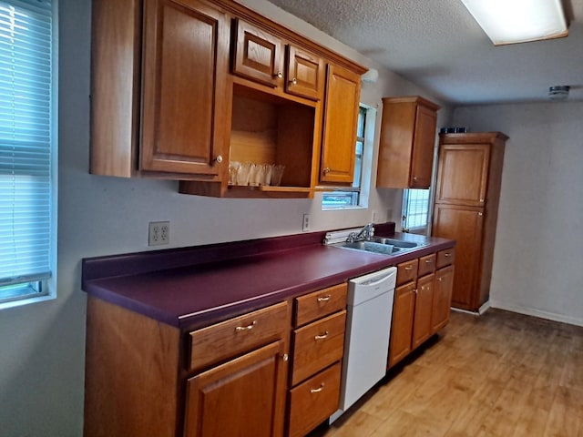 kitchen featuring a textured ceiling, sink, white dishwasher, and light hardwood / wood-style flooring