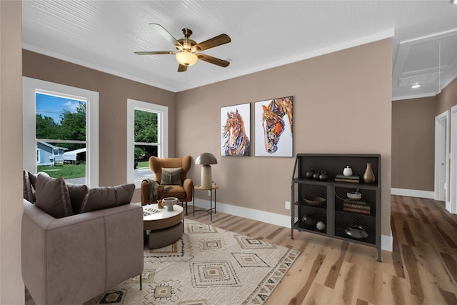 living room featuring hardwood / wood-style flooring, crown molding, and ceiling fan