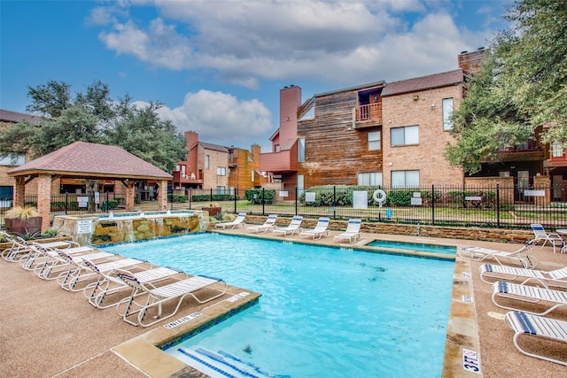 community pool with a gazebo, a patio area, and fence