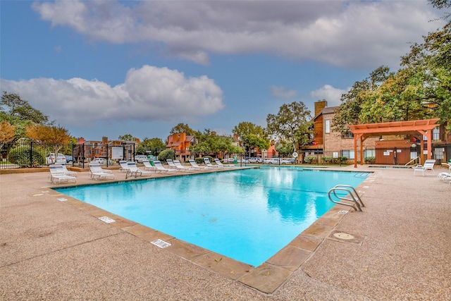 pool with a pergola, a patio area, and fence