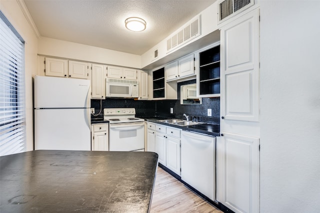 kitchen with white cabinets, decorative backsplash, sink, and white appliances