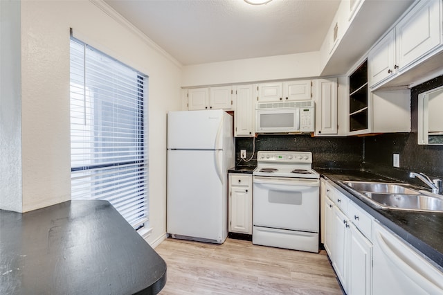 kitchen featuring white cabinets, white appliances, sink, and a wealth of natural light