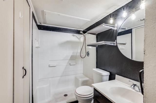 bathroom with vanity, toilet, and a tile shower