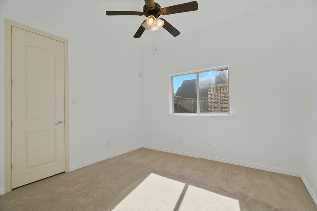 empty room featuring ceiling fan and light carpet