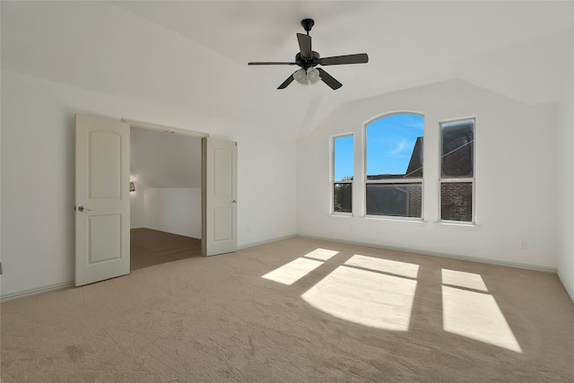 unfurnished bedroom featuring light carpet, ceiling fan, and vaulted ceiling