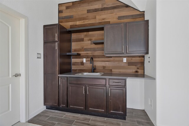 bar with sink and dark brown cabinetry