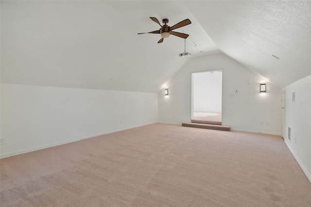 bonus room featuring lofted ceiling, a textured ceiling, light colored carpet, and ceiling fan