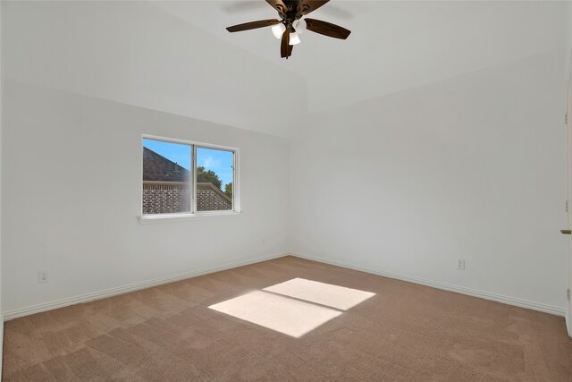 empty room featuring lofted ceiling, light carpet, and ceiling fan