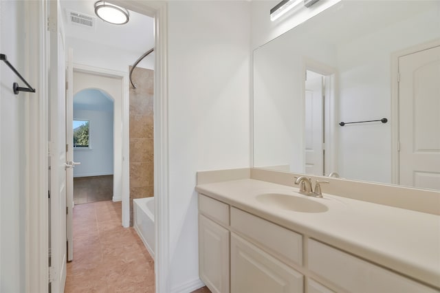 bathroom with tiled shower / bath, vanity, and tile patterned flooring