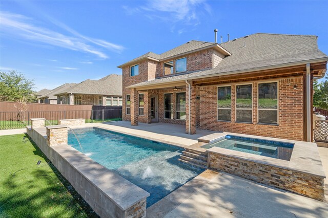 view of pool featuring a patio area, pool water feature, and an in ground hot tub