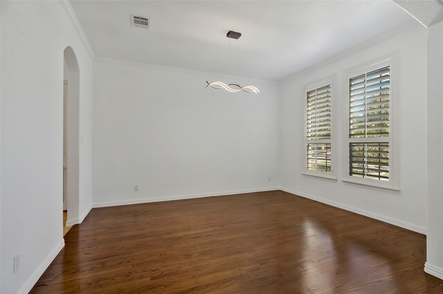 spare room featuring ornamental molding and dark hardwood / wood-style floors