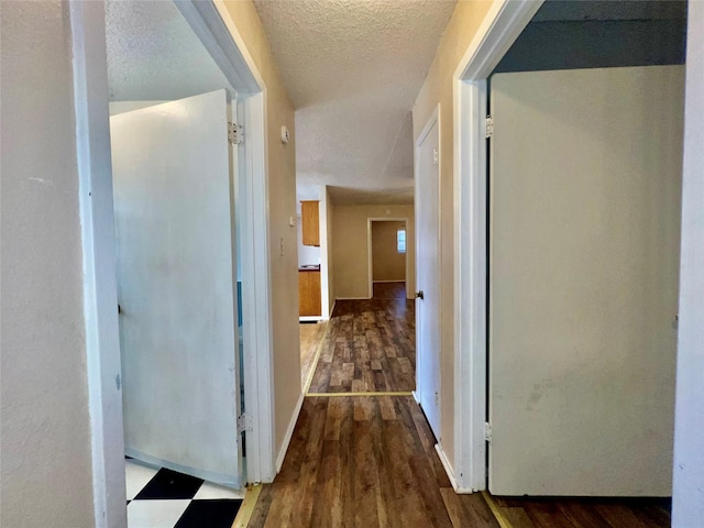 corridor featuring hardwood / wood-style floors and a textured ceiling