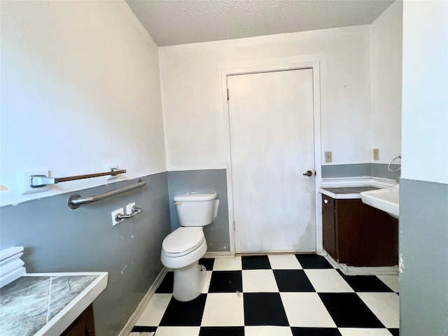 bathroom with a textured ceiling and toilet