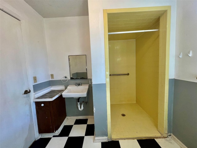 bathroom with tiled shower and sink