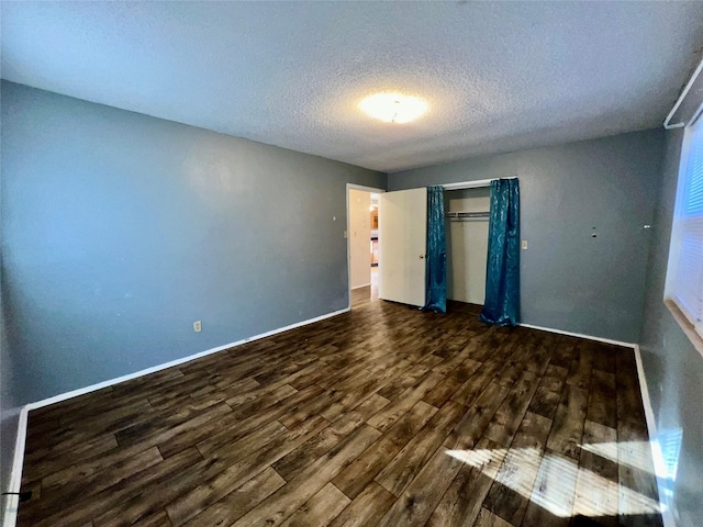 unfurnished bedroom featuring a closet, dark hardwood / wood-style floors, and a textured ceiling