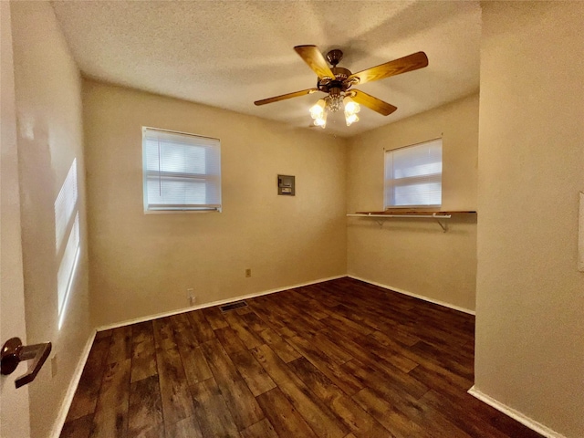 spare room with ceiling fan, dark wood-type flooring, and a textured ceiling