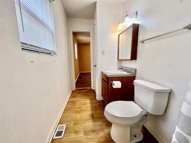 bathroom with vanity, toilet, and hardwood / wood-style floors