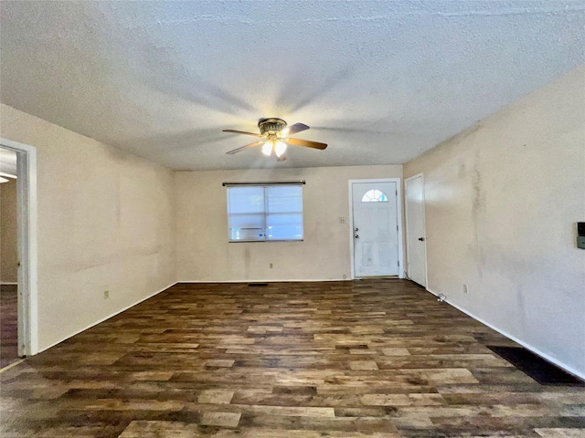 empty room featuring ceiling fan, dark hardwood / wood-style flooring, and a textured ceiling