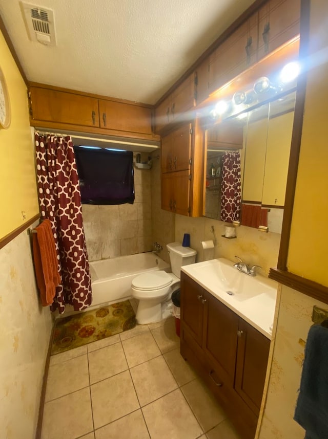 full bathroom featuring tile patterned floors, vanity, toilet, a textured ceiling, and shower / tub combo with curtain