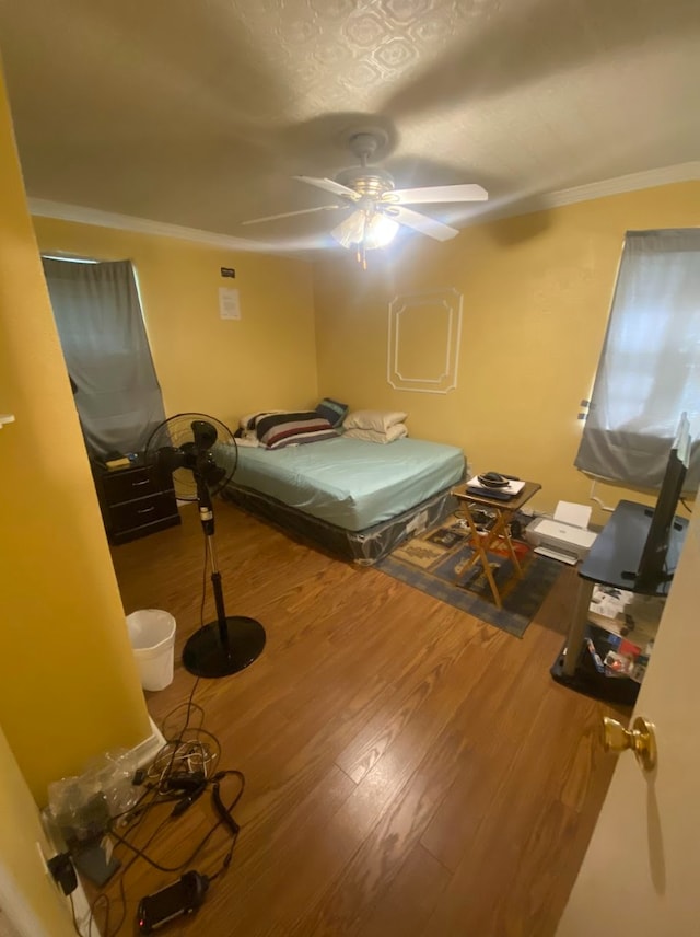 unfurnished bedroom with hardwood / wood-style flooring, ceiling fan, and crown molding