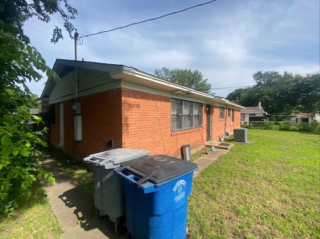 view of home's exterior featuring central air condition unit and a yard