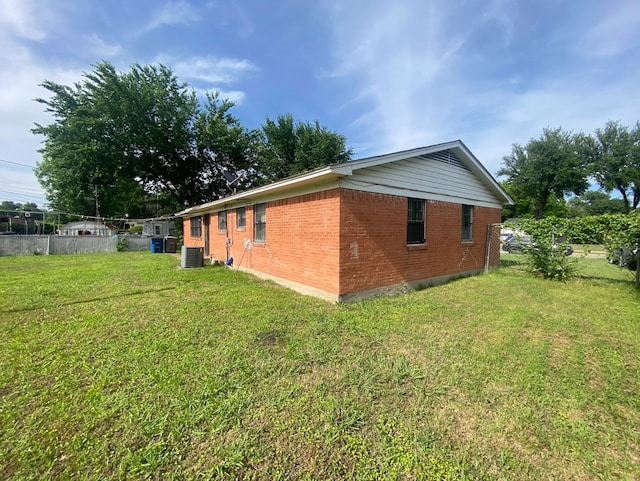 view of side of property with cooling unit and a lawn