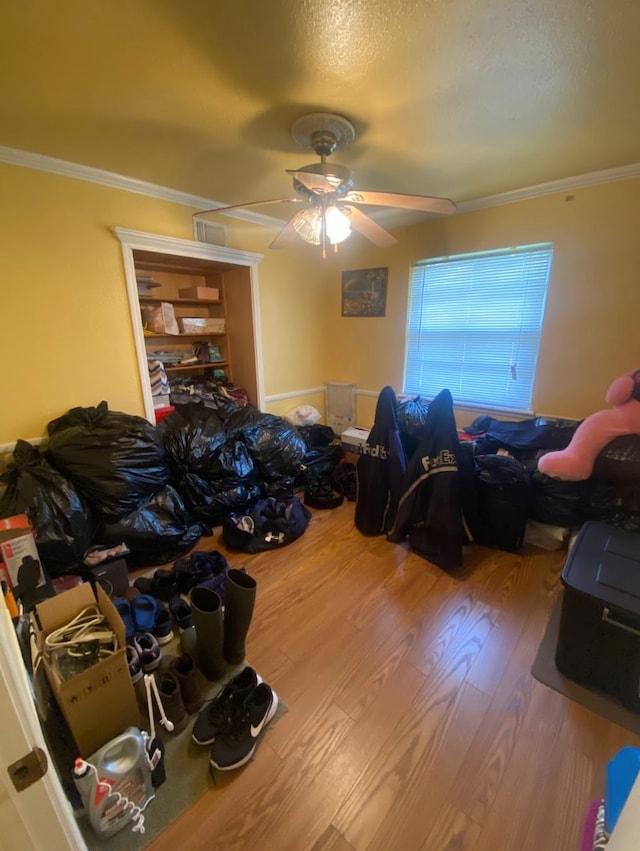 bedroom featuring ceiling fan, crown molding, and wood-type flooring