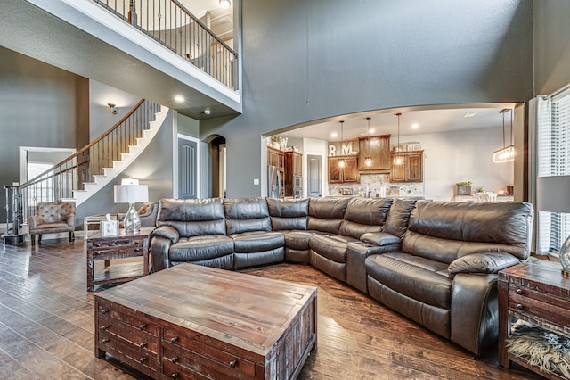 living room featuring dark hardwood / wood-style floors and a towering ceiling