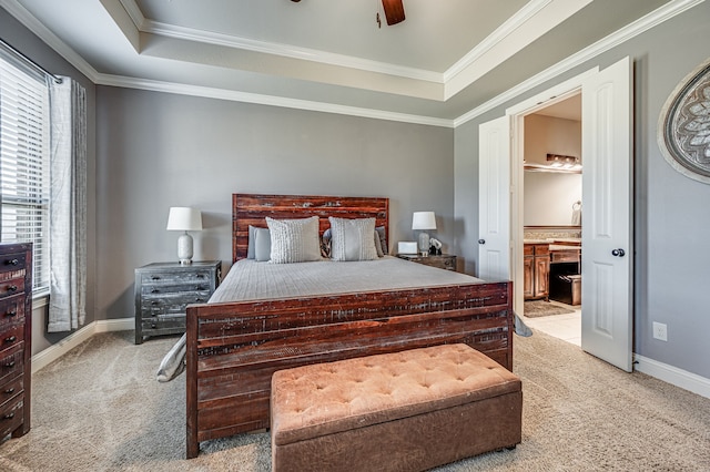 carpeted bedroom with ensuite bathroom, ceiling fan, a raised ceiling, and ornamental molding