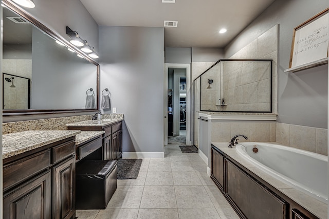 bathroom featuring vanity, shower with separate bathtub, washer / clothes dryer, and tile patterned floors