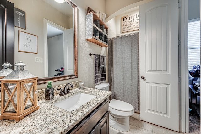 bathroom with walk in shower, tile patterned flooring, vanity, and toilet