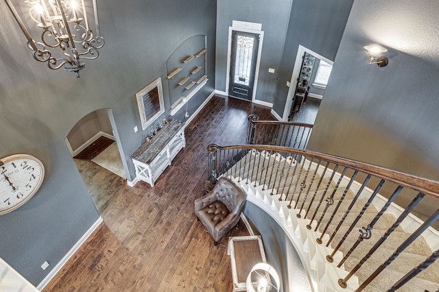 entrance foyer featuring dark wood-type flooring, a high ceiling, and an inviting chandelier