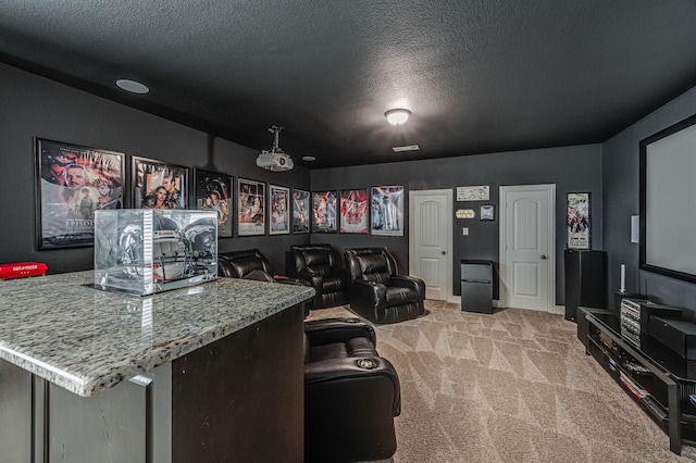 carpeted home theater room featuring a textured ceiling