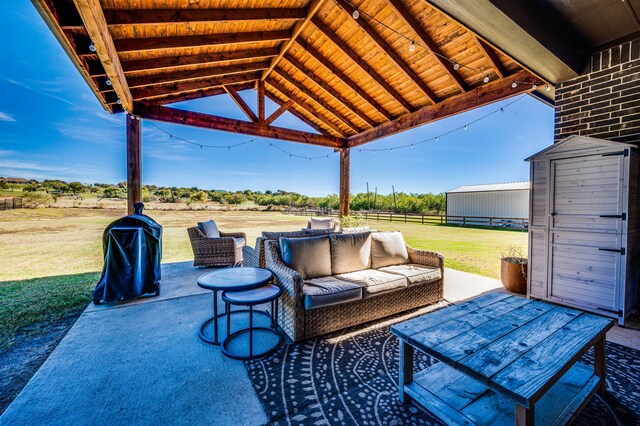 view of patio with a rural view, a shed, and area for grilling