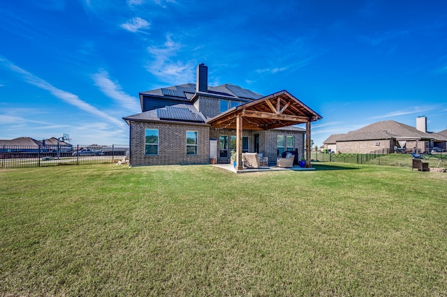 rear view of house featuring a lawn, an outdoor hangout area, and a patio area