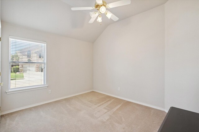 carpeted spare room with ceiling fan and vaulted ceiling