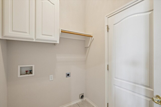 clothes washing area with hookup for an electric dryer, washer hookup, cabinets, and light tile patterned flooring