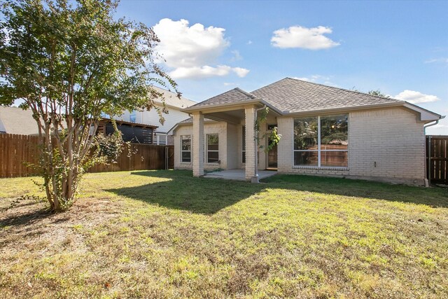 rear view of house featuring a patio area and a yard