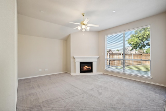 unfurnished living room with ceiling fan, lofted ceiling, and light colored carpet