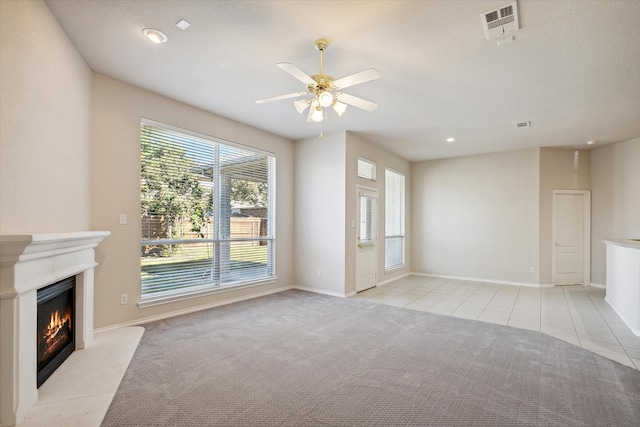 unfurnished living room featuring light tile patterned floors and ceiling fan