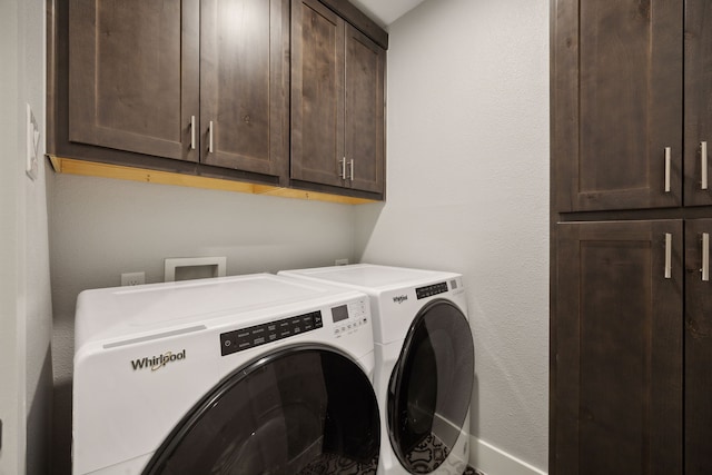 washroom with cabinets and washer and dryer