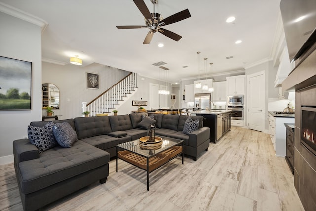 living room featuring light wood-type flooring, ceiling fan, crown molding, and sink