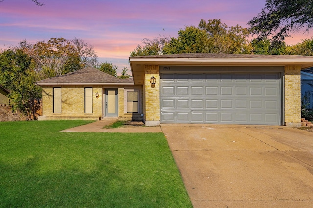 ranch-style house featuring a lawn and a garage