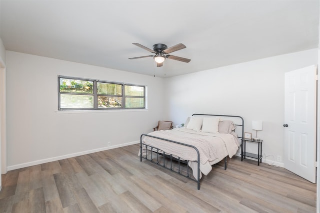 bedroom with light hardwood / wood-style floors and ceiling fan