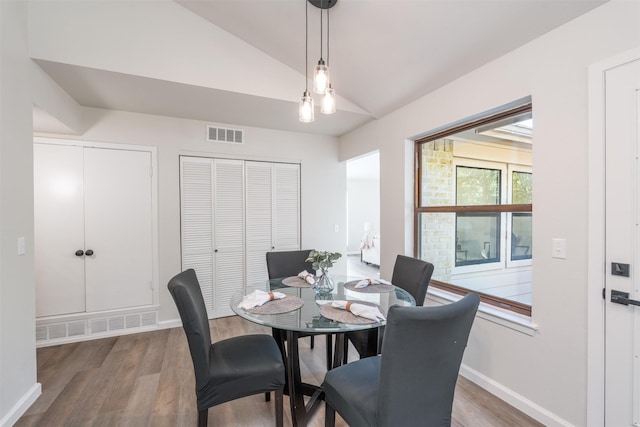 dining area with dark hardwood / wood-style flooring and lofted ceiling