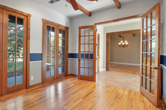 entryway with french doors, light hardwood / wood-style flooring, a wealth of natural light, and beam ceiling