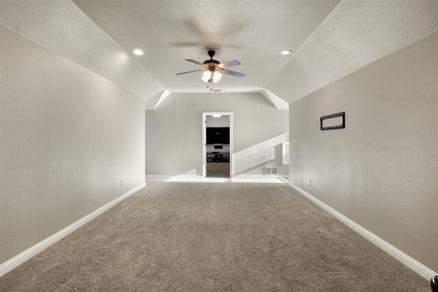 bonus room featuring lofted ceiling, a textured ceiling, ceiling fan, and carpet floors