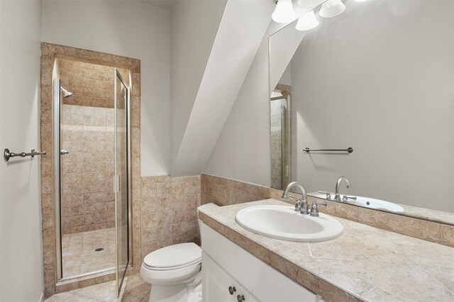 bathroom featuring vanity, toilet, an enclosed shower, and tile walls