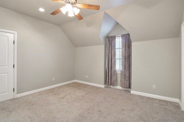 additional living space featuring light carpet, ceiling fan, and vaulted ceiling