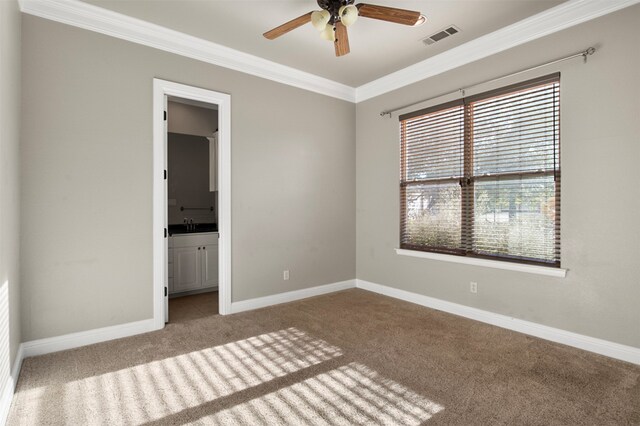 unfurnished bedroom featuring multiple windows, light carpet, ceiling fan, and ensuite bathroom